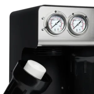 Close-up of a black espresso machine with two round pressure gauges on a stainless panel, and a portafilter holding a coffee puck.